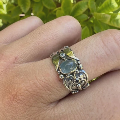 Bague anneau pour homme en argent massif d'inspiration celtique, médiévale. Bague sertie d'un cabochon d'aigue-marine de couleur bleu gris. Pierre  translucide propre à l'oeil. Bijou unique réalisé en taille 58. 