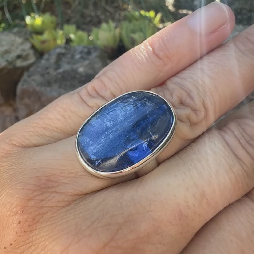 Bague pour femme en argent massif, sertie d'un cabochon de cyanite de couleur bleue denim. Pierre transparente de forme ovale. Bijou unique réalisée en taille 52 par Orchajewelry