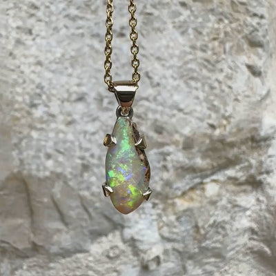 Pendentif pour femme en or 9k et argent massif 925 serti d'une opale cristal aux feux étoilés multicolores à dominantes vert et jaune. Cabochon de 3,3 carats de forme libre et de qualité translucide avec présence de roche mère. Bijou unique réalisé par Orchajewelry