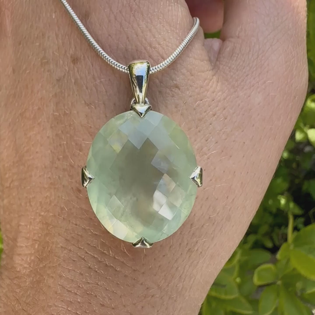 Pendentif ovale en argent massif, serti d'un cabochon facetté de préhnite de couleur verte pastel. Pierre de qualité translucide comportant des inclusions. Bijoux unique par Orcha Jewelry