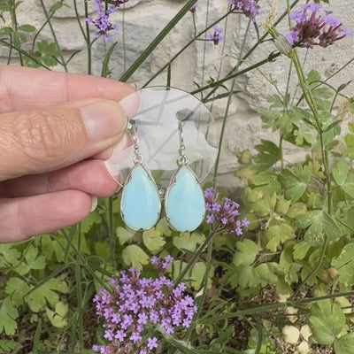 Boucles d'oreilles pendantes en argent massif serties d'opale bleue du Pérou. Pierres cabochon taillée en goutte de qualité opaque. Pierre naturelle de couleur bleu ciel. Bijoux unique, éthique et durable présenté dans un coffret de notre marque, prêt à offrir. Livraison offerte, certificat d'authenticité, service client.