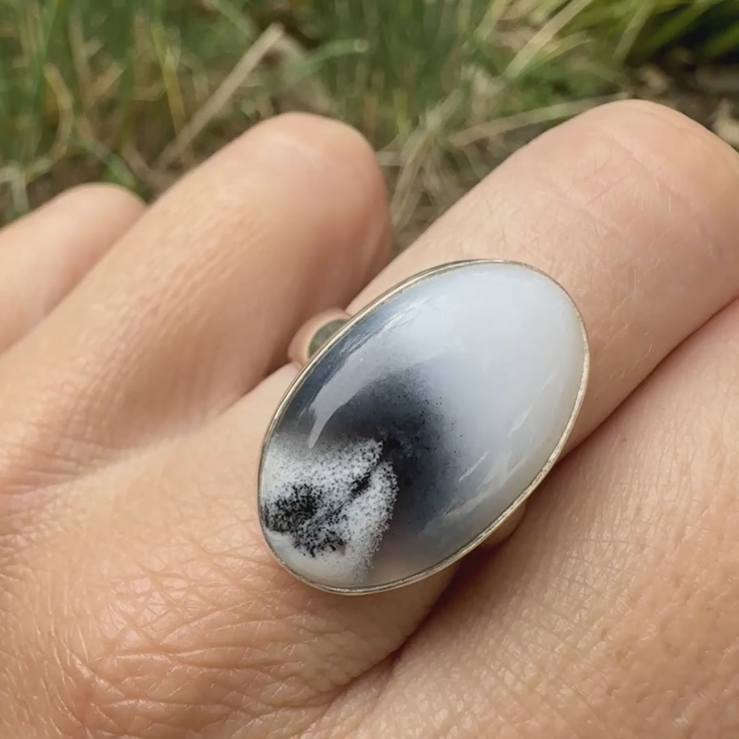 Bague pour femme en argent massif sertie d'un cabochon ovale d'agate dendritique de couleur blanc pur et noir. Pierre opaque translucide à inclusions paysages de dendrites de manganèse noires contrastées. Bijou unique réalisée en taille 54 par Orchajewelry