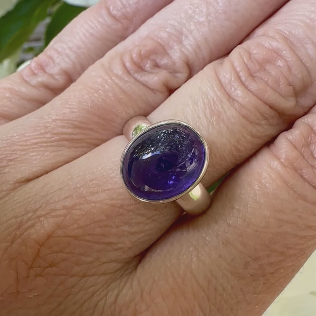 Vidéo d'une bague pour femme en argent massif, sertie d'un cabochon de tanzanite bleu lavande. Pierre taillée de forme ovale. Pierre transparente comportant des inclusions. Taille 58. Bijoux unique, éthique et durable présenté dans un coffret de notre marque, prêt à offrir. Livraison offerte, certificat d'authenticité, service client.