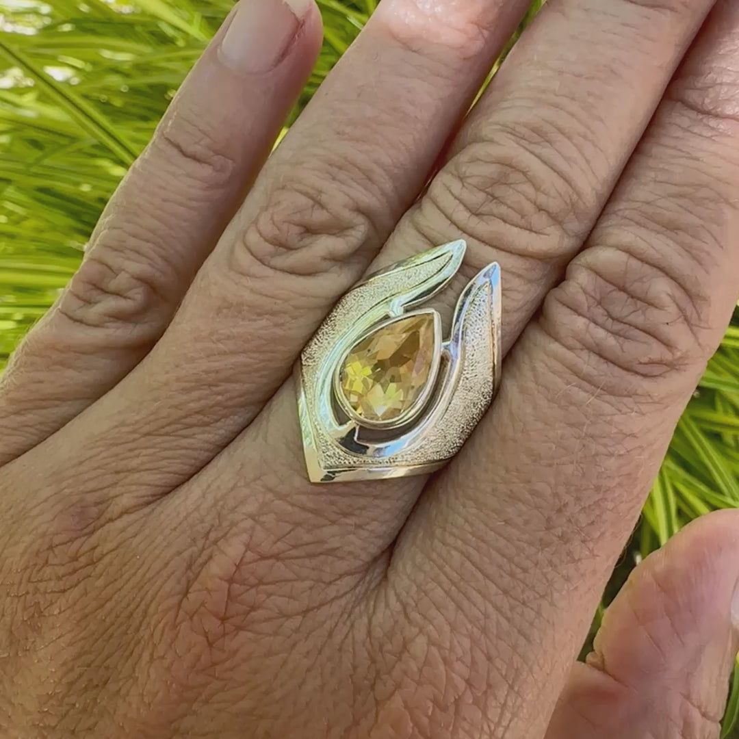 vidéo d"'une Grande bague contemporaine pour femme en argent massif sertie d'une Citrine. Pierre facettée en forme de goutte de qualité transparente, propre à l'oeil. Pierre naturelle de couleur jaune or lumineux. Bijoux unique, éthique et durable présenté dans un coffret de notre marque, prêt à offrir. Livraison offerte, certificat d'authenticité, service client.