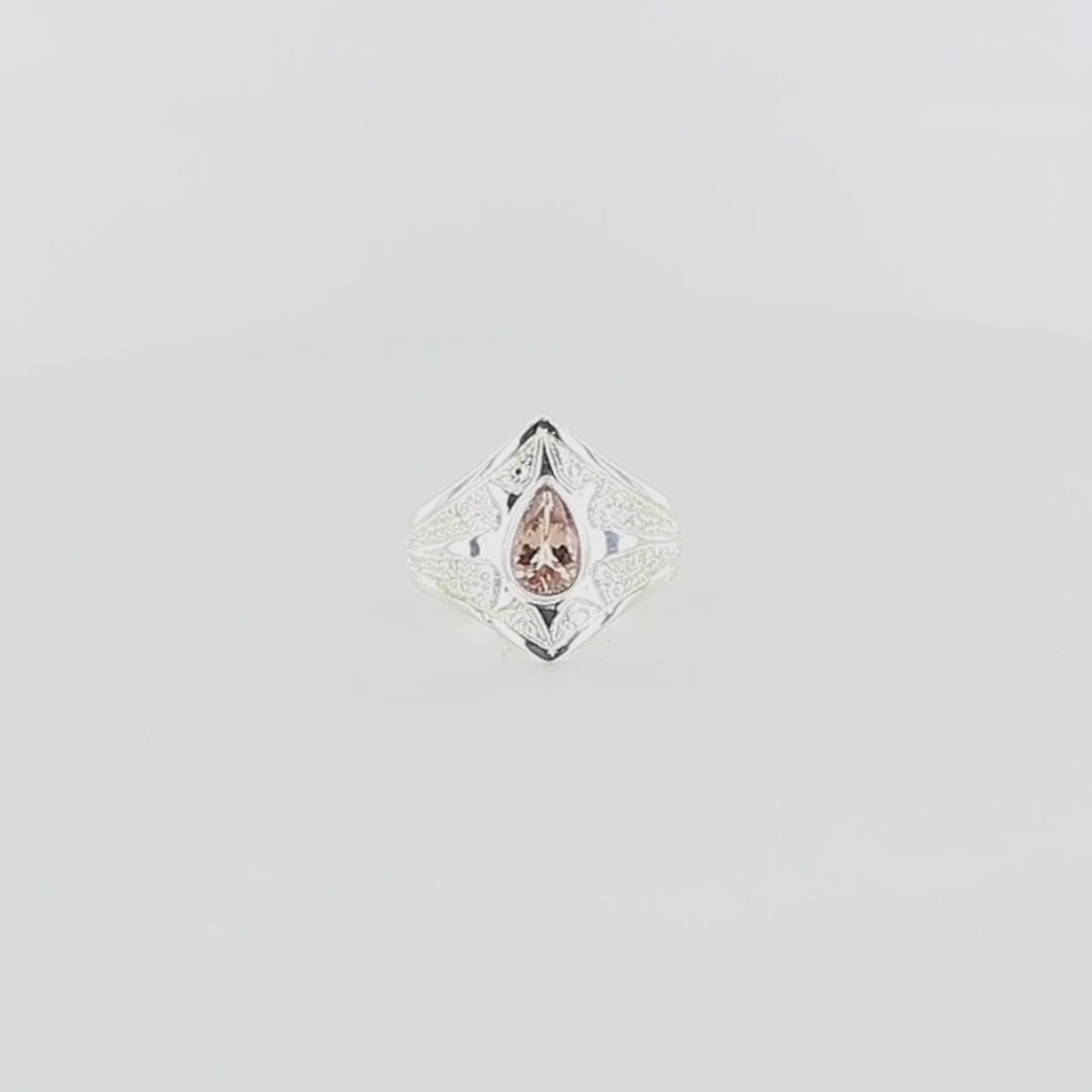 Bague pour femme en argent massif sculptées d'étoiles et autres corps célestes sertie d'une Tourmaline rose pêche. Pierre facettée en forme de goutte, de qualité transparente propre à l'oeil. Taille 61. Bijoux unique, éthique et durable présenté dans un coffret de notre marque, prêt à offrir. Livraison offerte, certificat d'authenticité, service client.