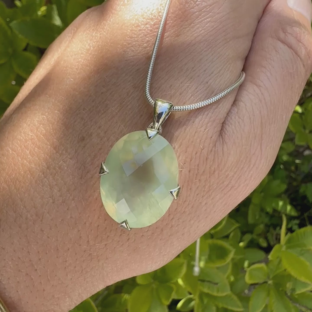 Pendentif ovale en argent massif, serti d'un cabochon facetté de préhnite de couleur verte jaune pastel. Pierre de qualité translucide comportant des inclusions. Bijoux unique par Orcha Jewelry
