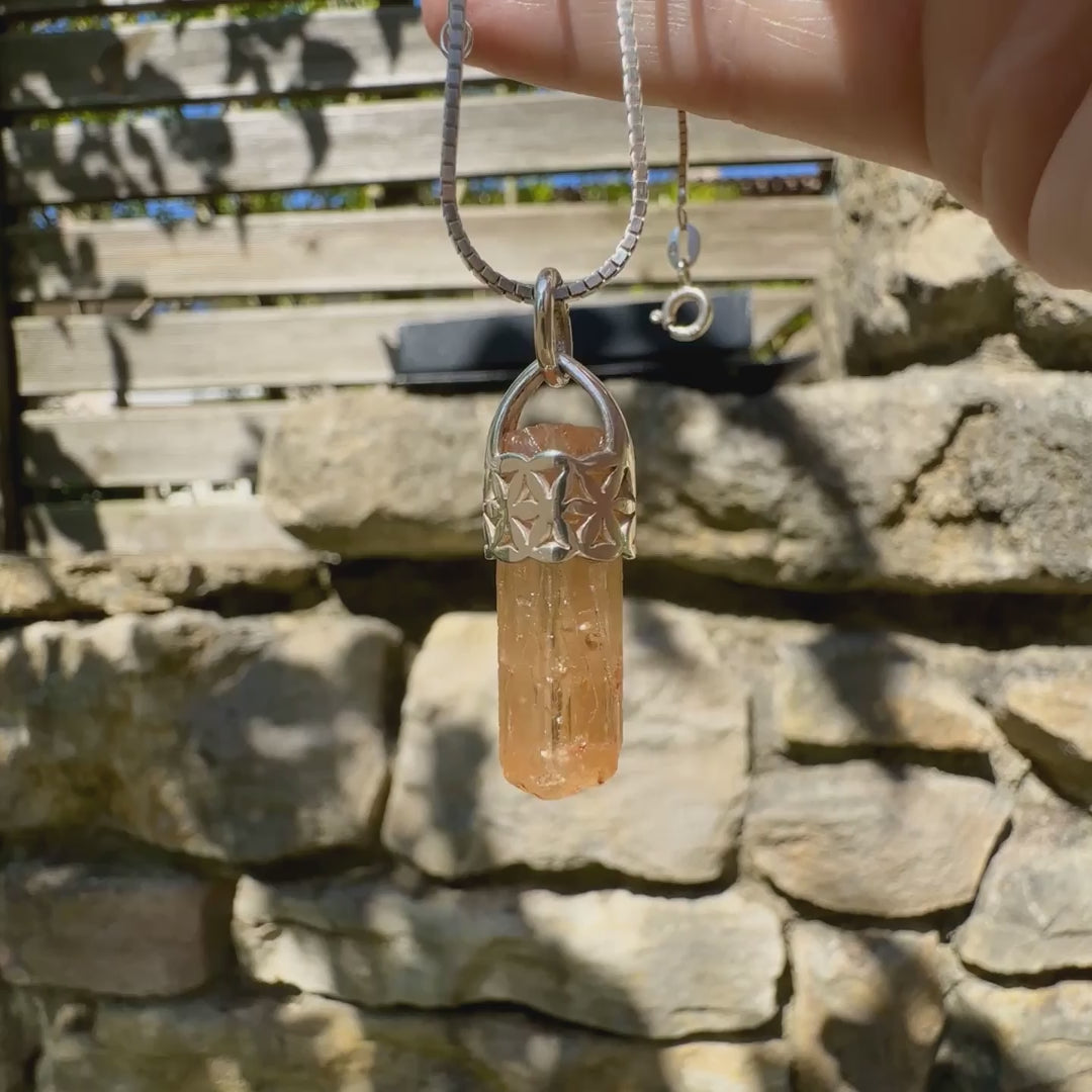 Vidéo d'un pendentif fleur de vie en argent massif serti d'un cristal de topaze impériale de couleur jaune arrangé. Cristal brute mate, transparent, présentant des inclusions internes et en surface. Bijoux unique, éthique et durable présenté dans un coffret de notre marque, prêt à offrir. Livraison offerte, certificat d'authenticité, service client.
