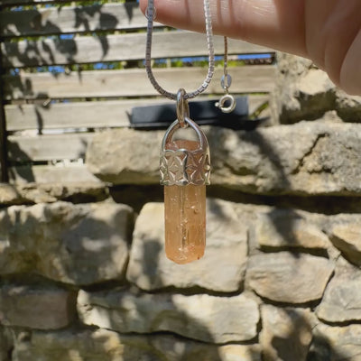 Vidéo d'un pendentif fleur de vie en argent massif serti d'un cristal de topaze impériale de couleur jaune arrangé. Cristal brute mate, transparent, présentant des inclusions internes et en surface. Bijoux unique, éthique et durable présenté dans un coffret de notre marque, prêt à offrir. Livraison offerte, certificat d'authenticité, service client.
