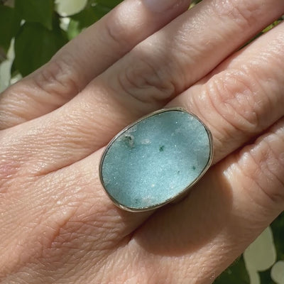 Bague pour femme en argent massif sertie d'un magnifique gemsilica druzy: chrysocale silicifiée recouverte de fins cristaux de quartz scintillants. Pierre de qualité opaque taillée en tranche de forme ovale. Pierre naturelle originaire de République dominicaine du Congo de couleur bleu clair turquoise. Bague réalisée en taille 58,5. Bijoux unique, éthique et durable présenté dans un coffret de notre marque, prêt à offrir. Livraison offerte, certificat d'authenticité, service client.
