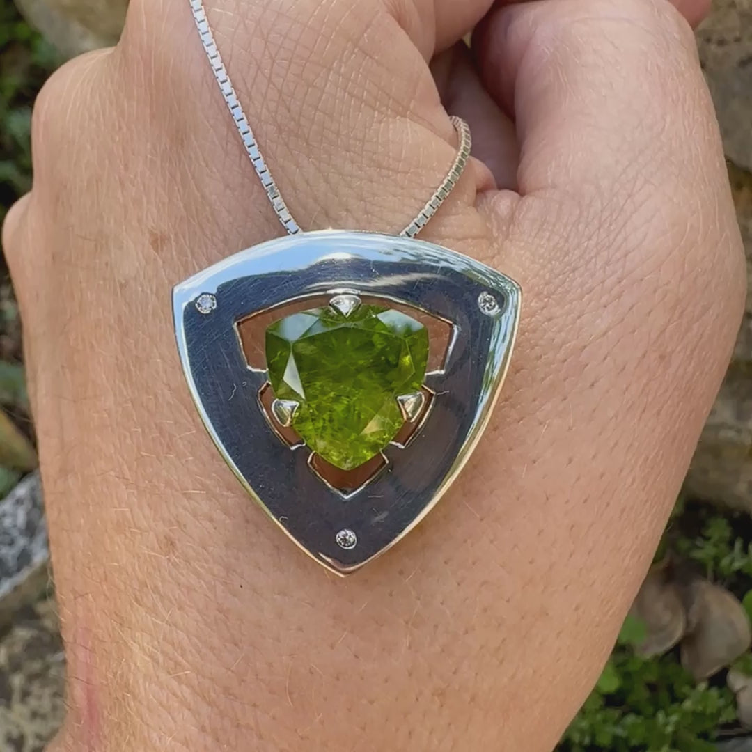 Pendentif contemporain pour femme en argent massif serti d'un péridot de couleur vert olive doré intense et de petits diamants. Pierre taillée, de forme triangulaire, transparente présentant de nombreuse inclusions. Bijou unique réalisé par Orchajewelry