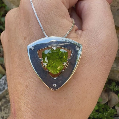 Pendentif contemporain pour femme en argent massif serti d'un péridot de couleur vert olive doré intense et de petits diamants. Pierre taillée, de forme triangulaire, transparente présentant de nombreuse inclusions. Bijou unique réalisé par Orchajewelry