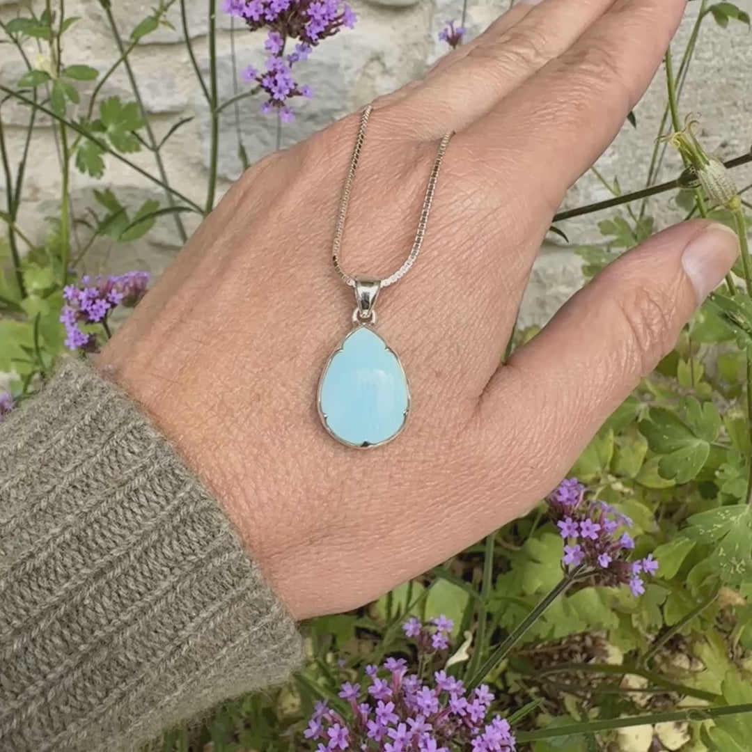 Pendentif pour femme en argent massif, sertie d'un cabochon d'opale bleue du Pérou de couleur bleu ciel clair. Pierre en forme de goutte. Pierre opaque. Bijoux unique, éthique et durable présenté dans un coffret de notre marque, prêt à offrir. Livraison offerte, certificat d'authenticité, service client.