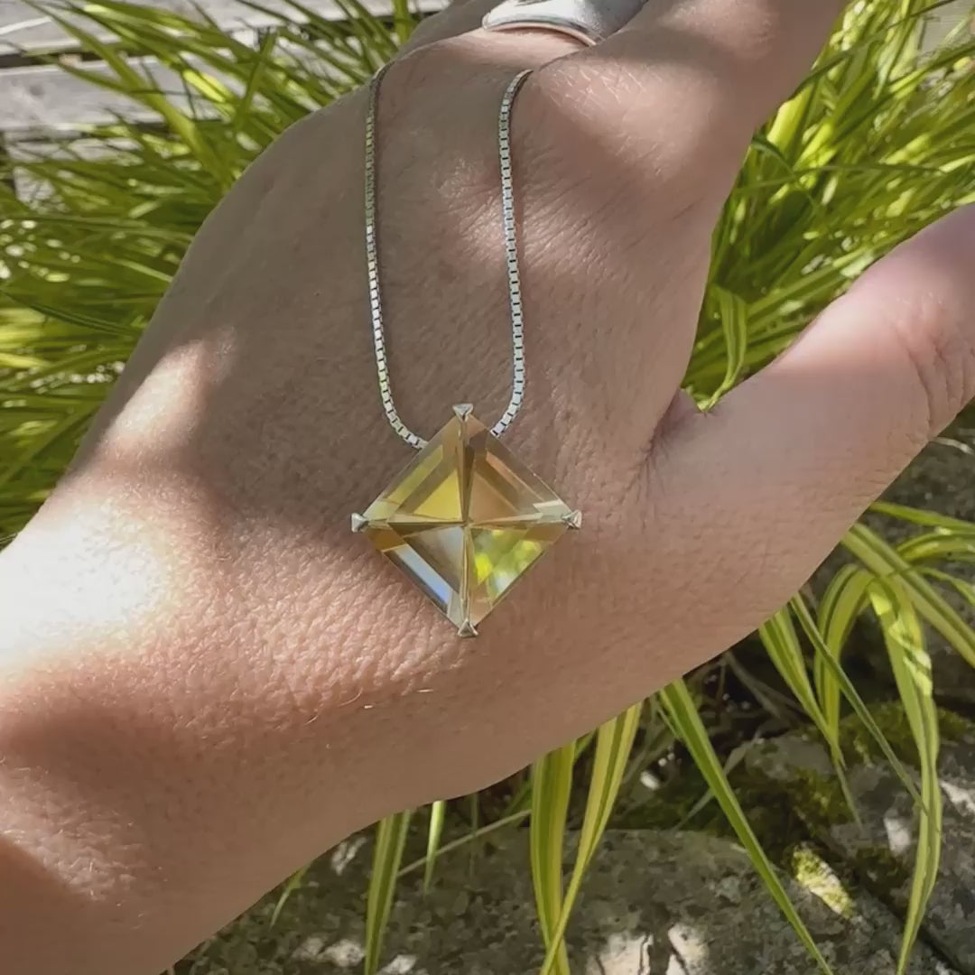 vidéo d'un collier solitaire pour femme en argent massif serti d'une Citrine. Pierre au nuance de couleur jaune clair à très clair , pierre facettée en forme de losange, qualité transparente propre à l'oeil. Pendentif monté sur une chaine en argent sterling de type maille carrée miroir de 1,3 mm d'épaisseur et de 40 cm de longueur. Bijoux unique, par orcha jewelry, éthique et durable présenté dans un coffret de notre marque, prêt à offrir. Livraison offerte, certificat d'authenticité, service client.