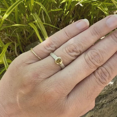 Vidéo d'une bague anneau pour femme en argent massif et or sertie d'une Héliodore. Pierre facettée de forme ronde, de qualité transparente, propre à l'oeil. Pierre naturelle de couleur jaune doré lumineux. Bijoux unique, éthique et durable présenté dans un coffret de notre marque, prêt à offrir. Livraison offerte, certificat d'authenticité, service client.