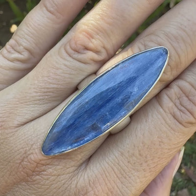 Bague marquise pour femme en argent massif sertie d'un cabochon de cyanite de couleur bleu jean nacré. Pierre translucide à inclusions. Bijou unique réalisée en taille 58 par Orchajewelry