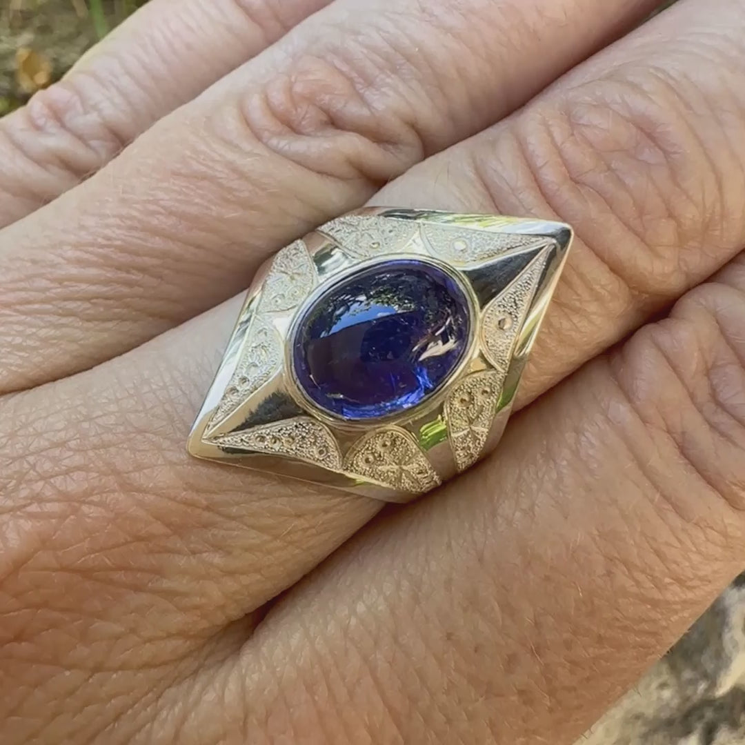 Vidéo d'une grande Bague pour femme en argent massif, sertie d'un cabochon de tanzanite bleu lavande. Pierre taillée de forme ovale. Pierre transparente comportant des inclusions. Taille 59. Bijoux unique, éthique et durable présenté dans un coffret de notre marque, prêt à offrir. Livraison offerte, certificat d'authenticité, service client.