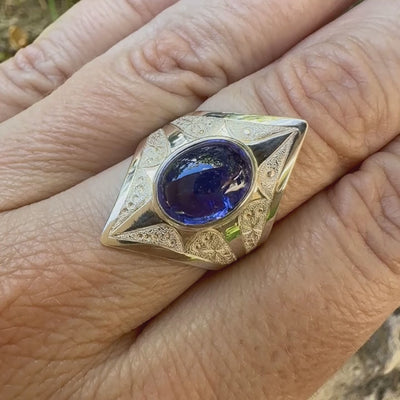 Vidéo d'une grande Bague pour femme en argent massif, sertie d'un cabochon de tanzanite bleu lavande. Pierre taillée de forme ovale. Pierre transparente comportant des inclusions. Taille 59. Bijoux unique, éthique et durable présenté dans un coffret de notre marque, prêt à offrir. Livraison offerte, certificat d'authenticité, service client.