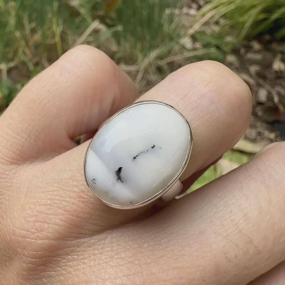 Bague pour femme en argent massif sertie d'un cabochon ovale d'agate dendritique de couleur blanc pur et noir. Pierre opaque à inclusions paysages de dendrites de manganèse noires contrastées. Bijou unique réalisée en taille 54 par Orchajewelry