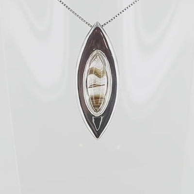 Pendentif en argent massif en forme d'amande, orné d'un quartz rutile doré naturel à inclusions filamenteuses, serti clos au centre d'une monture biseautée au design contemporain. Bijoux unique, éthique et durable présenté dans un coffret de notre marque, prêt à offrir. Livraison offerte, certificat d'authenticité, service client.