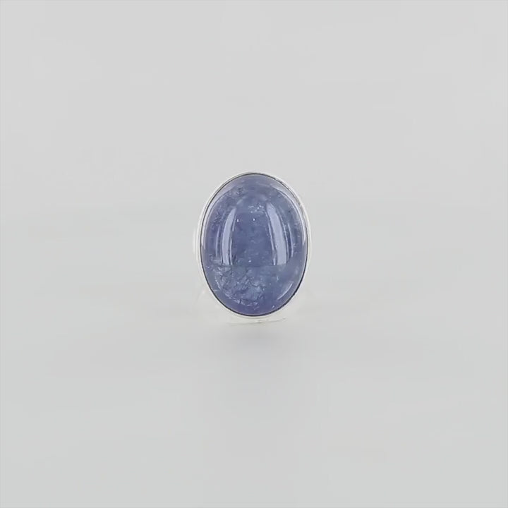 Bague de créateur en argent massif pour femme sertie d'une Tanzanite. Pierre cabochon de forme ovale de qualité translucide avec inclusions. Pierre naturelle de couleur bleu lavande. Bague réalisée en taille 52. Bijoux unique, éthique et durable présenté dans un coffret de notre marque, prêt à offrir. Livraison offerte, certificat d'authenticité, service client.