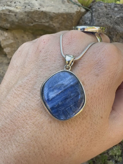 Pendentif en argent massif serti d'un cabochon de cyanite de couleur bleue jeans nacré. Pierre de qualité opaque comportant des inclusions. Bijoux unique par Orcha Jewelry
