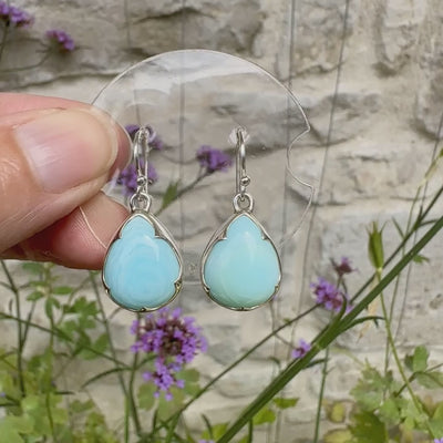 Boucles d'oreilles pendantes en argent massif serties d'opale bleue du Pérou. Pierres cabochon taillée en goutte de qualité opaque. Pierre naturelle de couleur bleu ciel. Bijoux unique, éthique et durable présenté dans un coffret de notre marque, prêt à offrir. Livraison offerte, certificat d'authenticité, service client.
