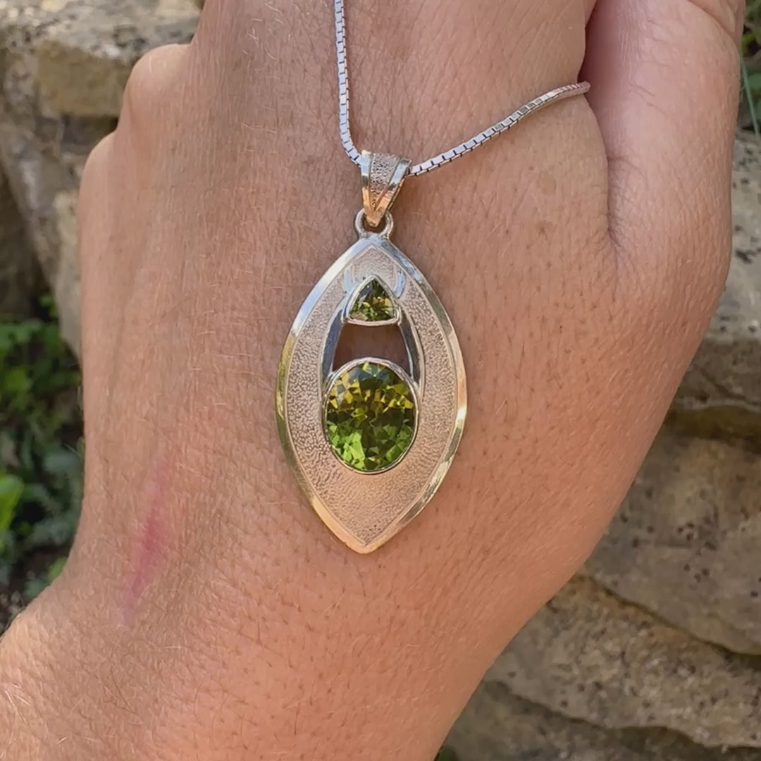 Pendentif pour femme en argent massif serti d'un péridot de couleur vert olive doré intense. Pierre taillée, de forme ovale, transparente propre à l'oeil. Bijou unique réalisé par Orchajewelry
