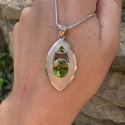 Pendentif pour femme en argent massif serti d'un péridot de couleur vert olive doré intense. Pierre taillée, de forme ovale, transparente propre à l'oeil. Bijou unique réalisé par Orchajewelry
