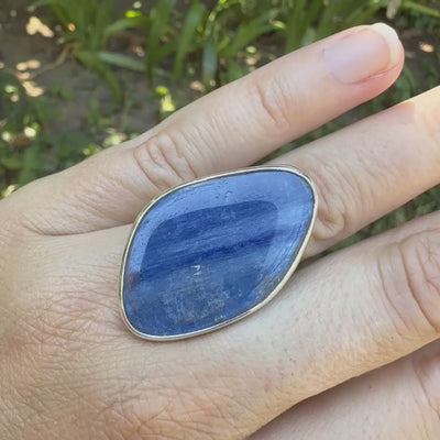 Bague pour femme en argent massif sertie d'un cabochon de cyanite de couleur bleu jean nacré. Pierre translucide à inclusions. Bijou unique réalisée en taille 54 par Orcha Jewelry