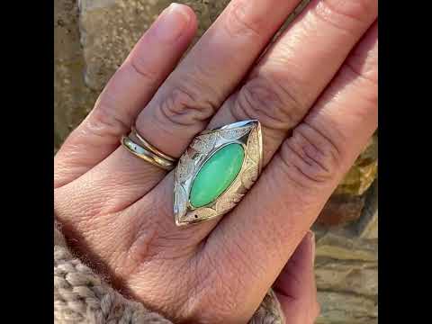Bague marquise pour femme en argent massif sculptées d'étoiles et autres corps célestes sertie d'un cabochon de chrysoprase de couleur verte pastel. Pierre naturelle de qualité translucide taillée en ovale longiligne. Bague unique réalisée en taille 57 par Orcha jewelry