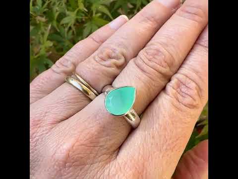 Bague pour femme en argent massif sertie d'un cabochon de chrysoprase de couleur vert émeraude pastel. Pierre translucide taillée en forme de goutte. Bijou unique réalisé en taille 58 par Orcha Jewelry