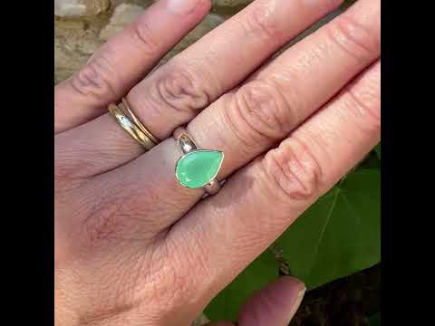 Bague pour femme en argent massif sertie d'un cabochon de chrysoprase de couleur vert émeraude pastel. Pierre translucide taillée en forme de goutte. Bijou unique réalisé en taille 56 par Orcha Jewelry