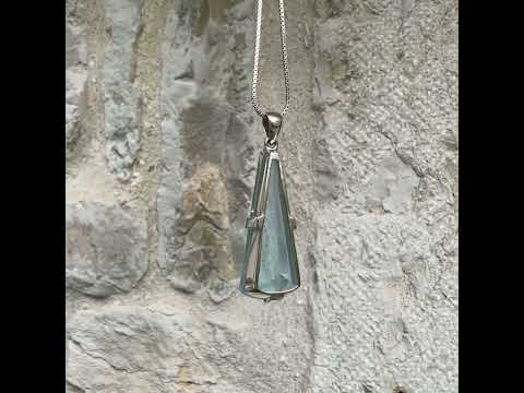 Pendentif en argent massif sertie d'une aigue marine taillée de 32 carats de couleur bleu clair profond et lumineux, pierre transparente avec inclusions. Pierre naturelle facettée de forme triangulaire allongé. Bijoux unique réalisée par Orchajewelry