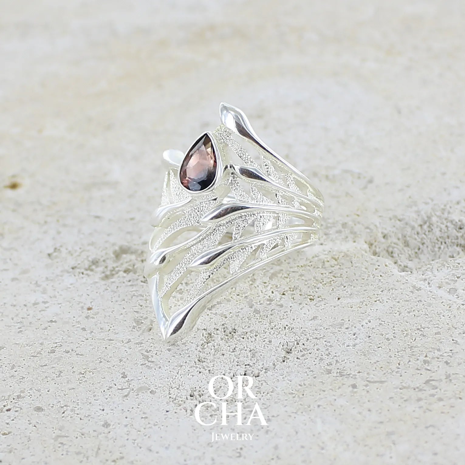 profil d'une Grande Bague pour femme en argent massif, sertie d'une Tourmaline bicolore rose pêche et bleue nuit. Pierre facettée en forme de goutte. Pierre incolore, très lumineuse et propre à l'oeil. Bijoux unique au design de feuillage tropicale travaillé en filigrane réalisé en taille 54.