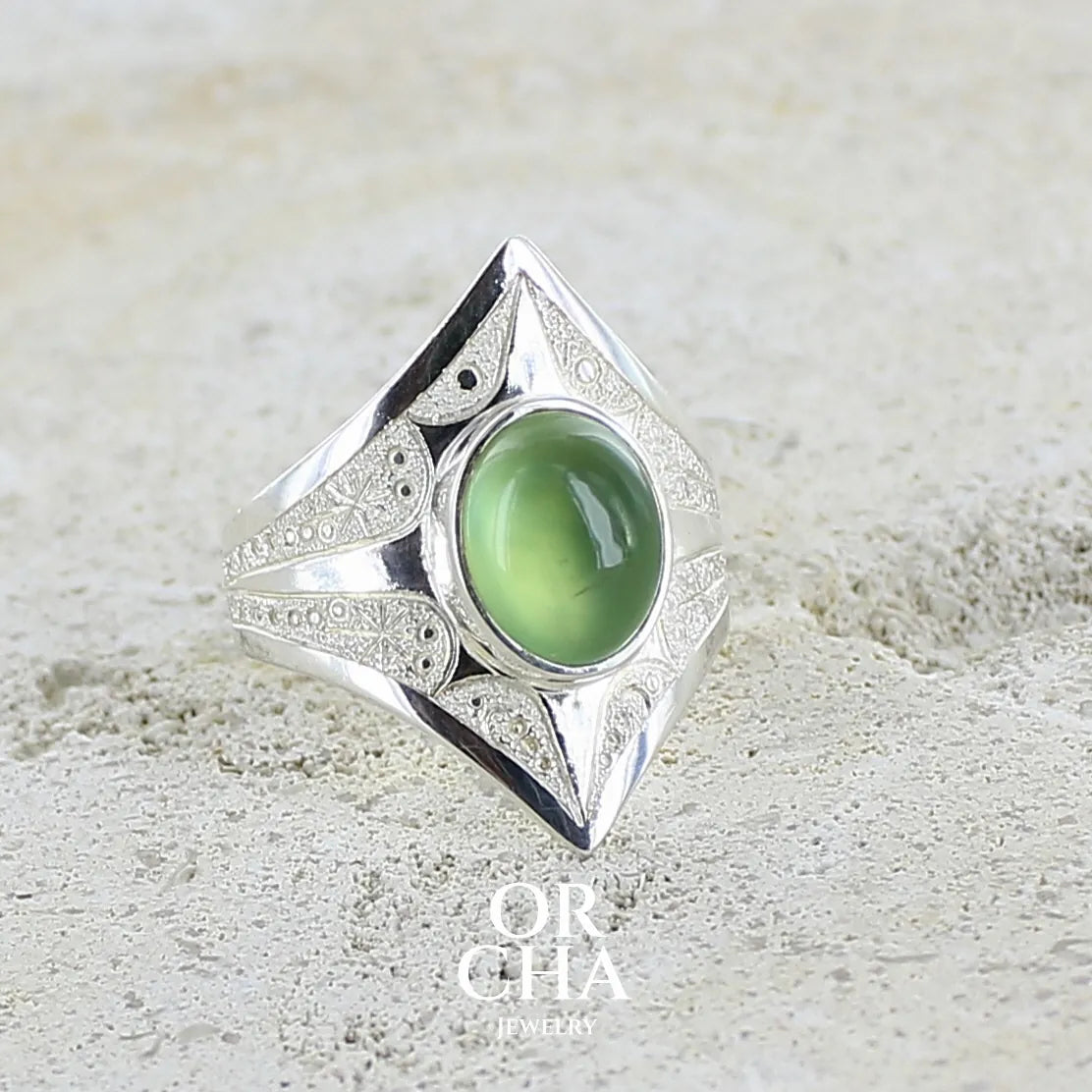 profil d'une Bague pour femme en argent massif sculptées d'étoiles et autres corps célestes sertie d'un cabochon ovale de préhnite de couleur verte pastel lumineuse. Pierre naturelle de qualité transparente présentant des inclusions. Bijoux unique réalisé en taille 54,5 par Orchajewelry.