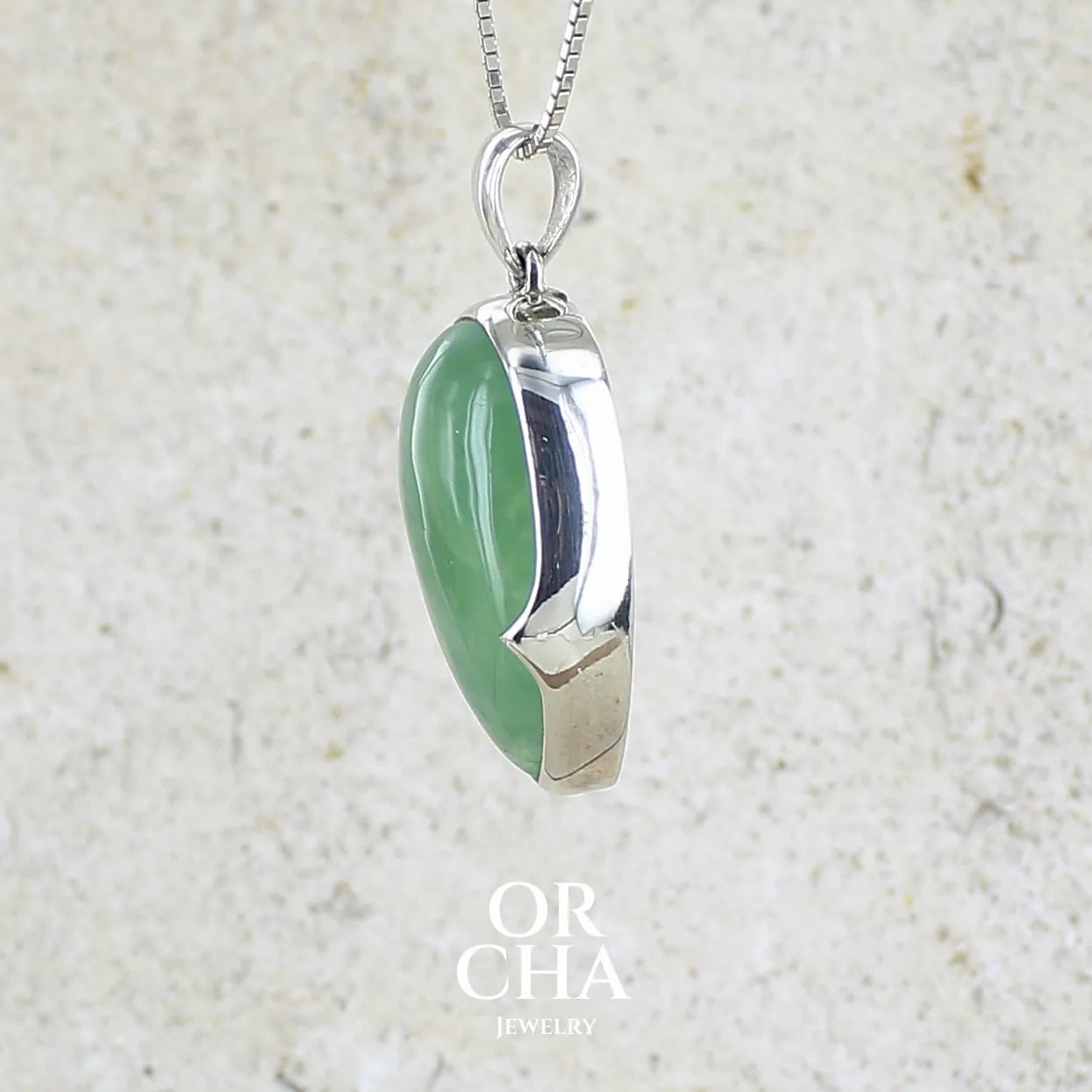 Profil d'un Pendentif pour femme en argent massif serti d'une préhnite de couleur vert jaune clair. Pierre naturelle taillée en cabochon en forme de goutte. Bijoux unique par orchajewelry.