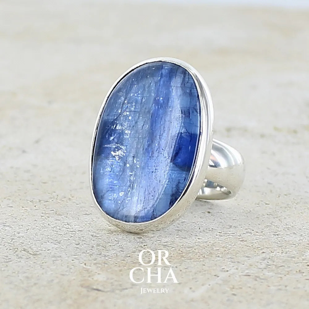 profil gauche d'une bague pour femme en argent massif, sertie d'un cabochon de cyanite de couleur bleue denim. Pierre transparente de forme ovale. Bijou unique réalisée en taille 52 par Orchajewelry