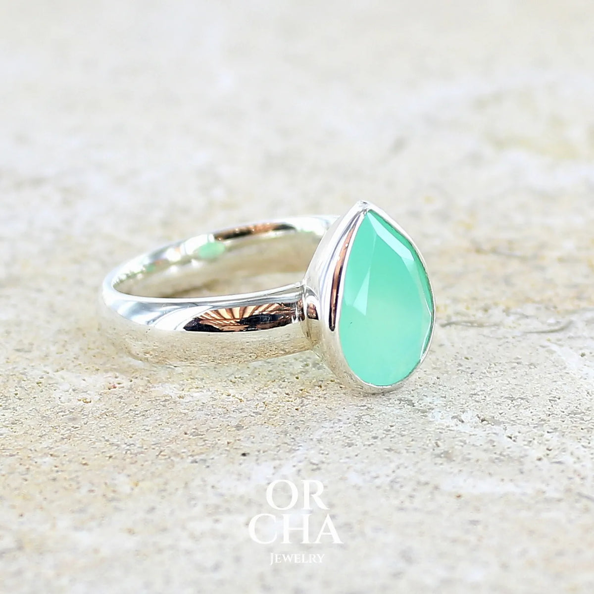 profil d'une bague pour femme en argent massif sertie d'un cabochon de chrysoprase de couleur vert émeraude pastel. Pierre translucide taillée en forme de goutte. Bijou unique réalisé en taille 58 par Orcha Jewelry
