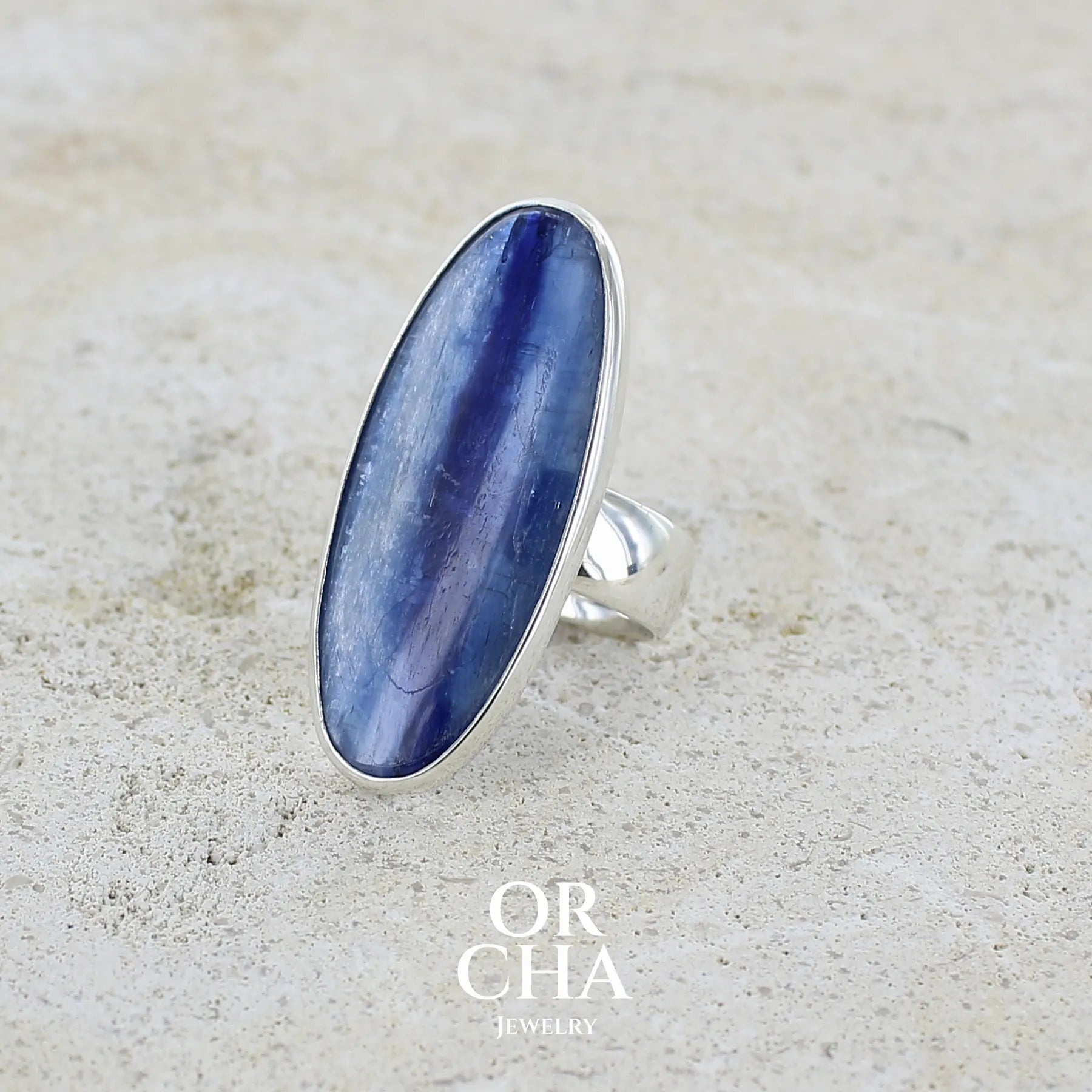profil d'une grande Bague pour femme en argent massif, sertie d'un long cabochon ovale de cyanite de couleur bleu denim nacré. Pierre de qualité translucide. Bijou unique réalisée en taille 58 par Orcha jewelry