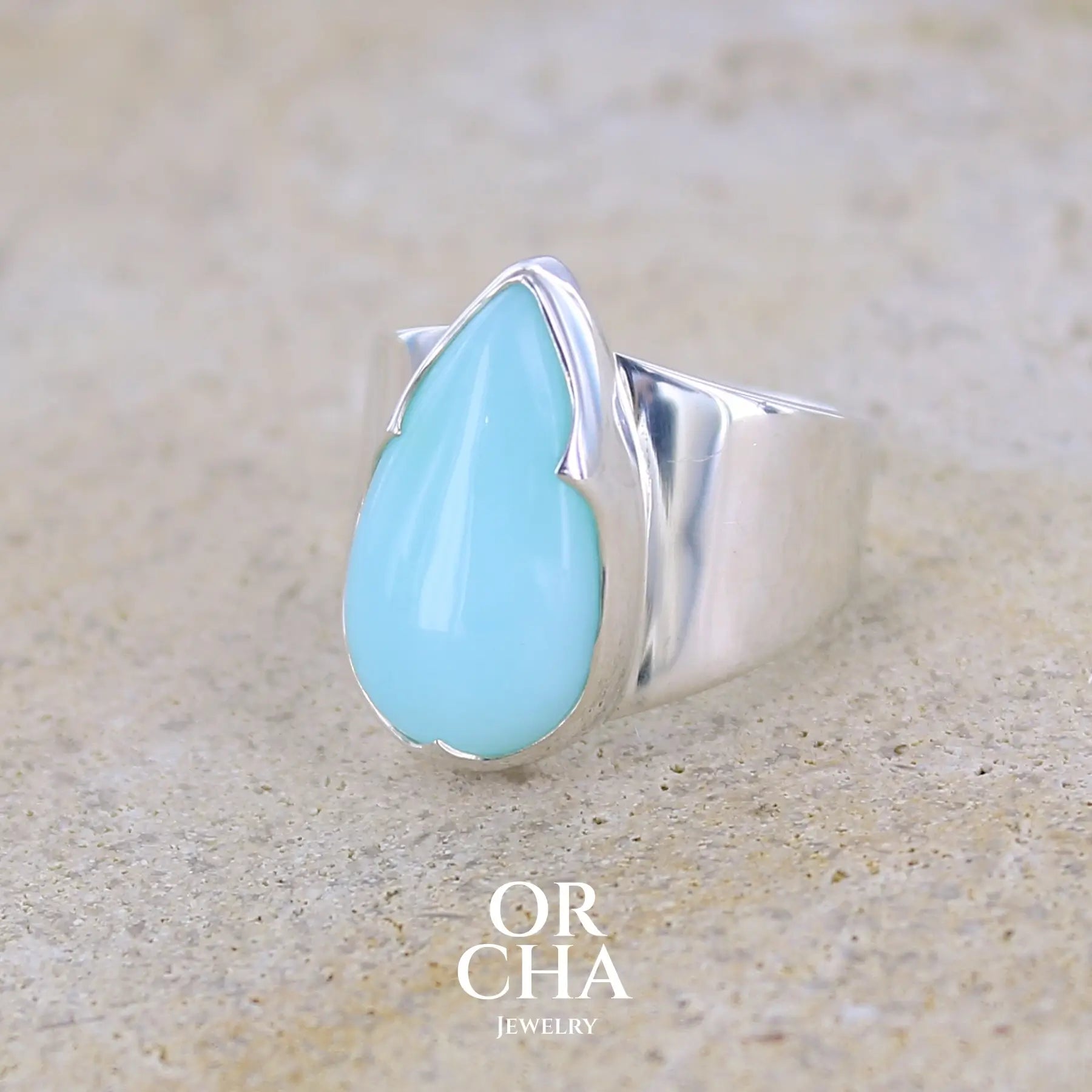 profil gauche d'une bague pour femme en argent massif, sertie d'un cabochon d'opale bleue du Pérou. Pierre taillée en forme de longue goutte. Pierre opaque. Taille 54. Bijoux unique, éthique et durable présenté dans un coffret de notre marque, prêt à offrir. Livraison offerte, certificat d'authenticité, service client.
