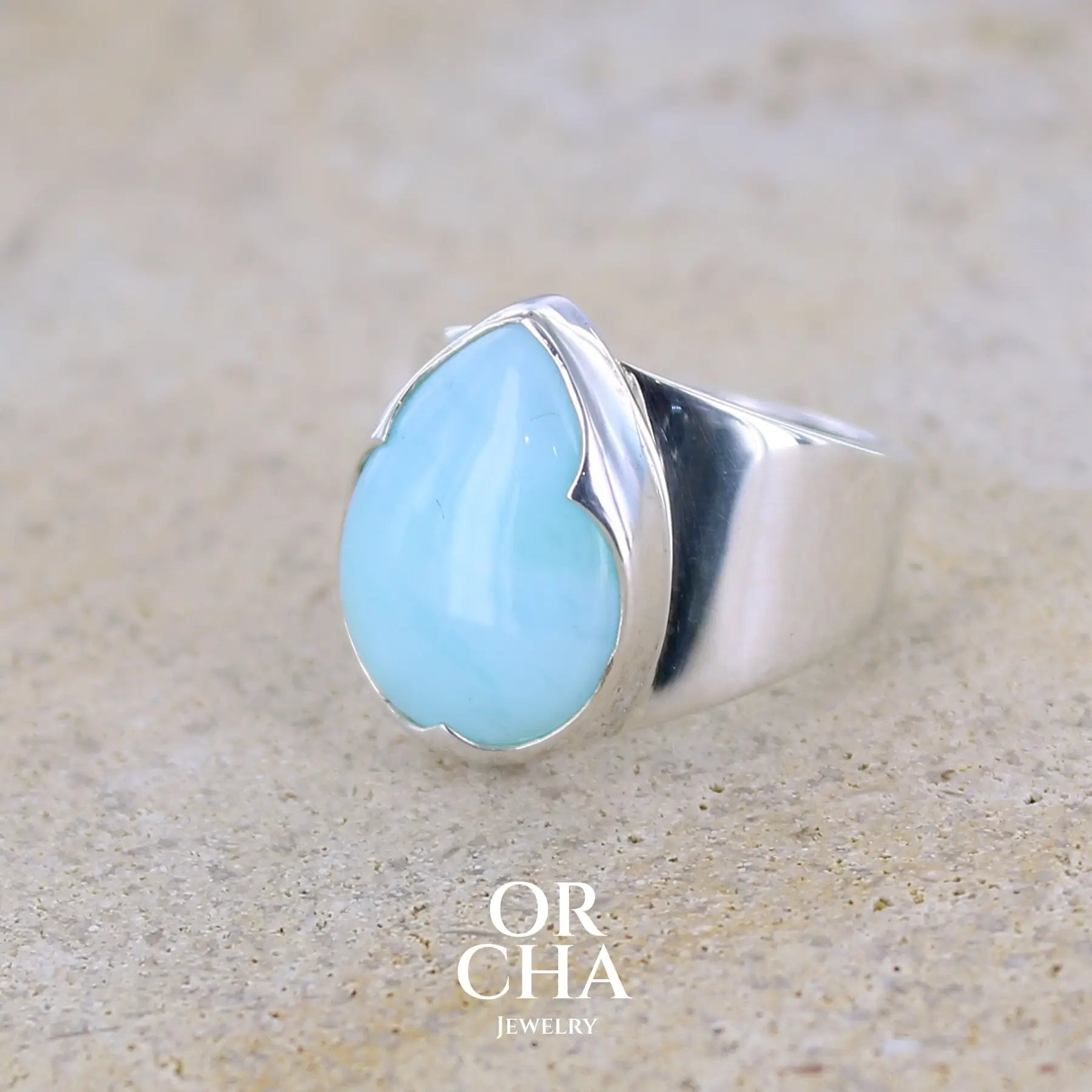profil gauche d'une bague pour femme en argent massif sertie d'une Opale bleue du Pérou. Pierre naturelle de couleur bleu ciel, taillée en cabochon en forme de goutte, de qualité opaque. Taille 51. Bijoux unique, éthique et durable présenté dans un coffret de notre marque, prêt à offrir. Livraison offerte, certificat d'authenticité, service client.