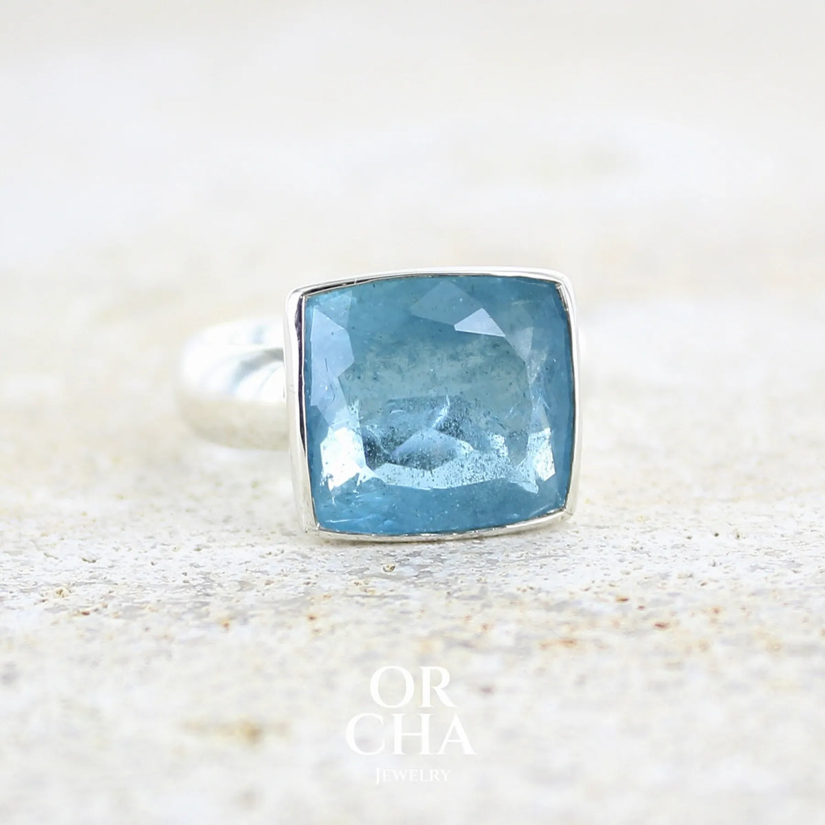 profil droit d'une bague cocktail pour femme en argent massif sertie d'une aigue marine taillée de 10 carats de couleur bleue gris foncé, pierre transparente avec inclusions. Pierre naturelle facettée de forme rectangulaire. Bijoux unique réalisée en taille 60,5 par Orchajewelry