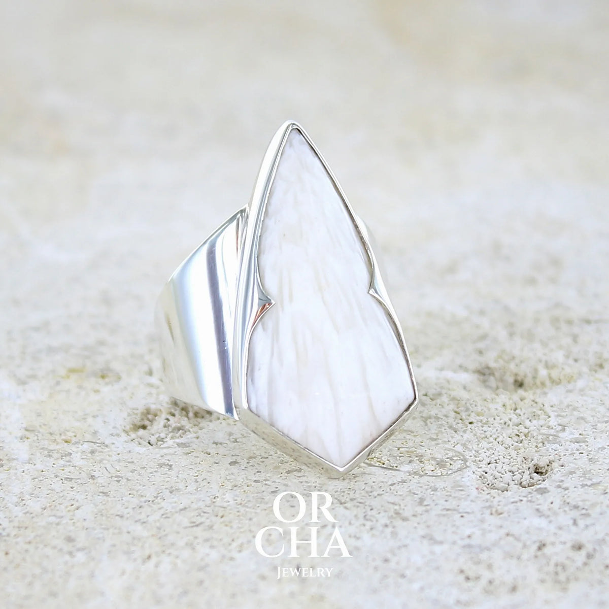 profil droit d'une bague contemporaine pour femme en argent massif sertie d'une scolecite blanche. Pierre naturelle de qualité opaque taillée en forme de losange. Bague unique réalisée en taille 56 par Orcha jewelry