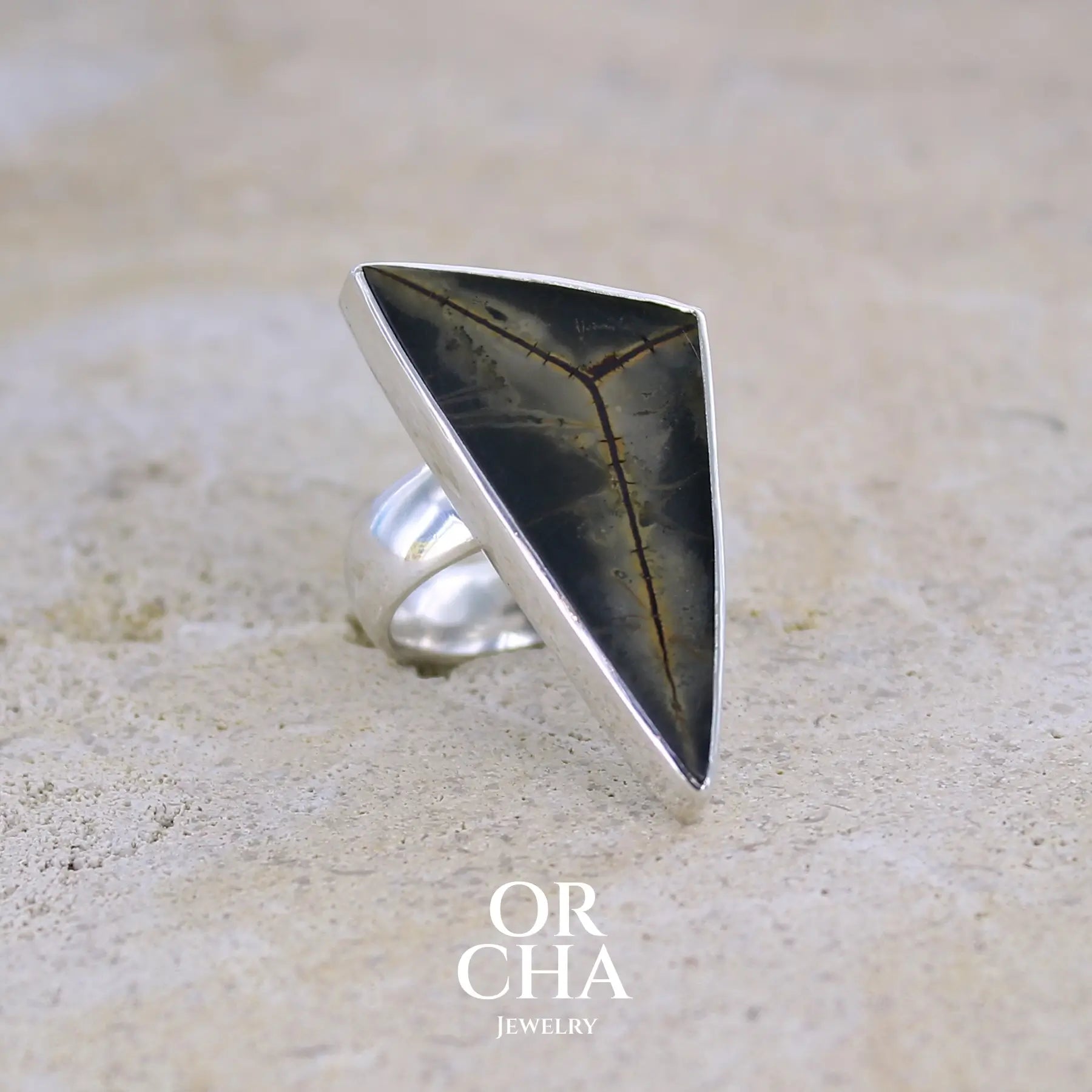 profil droit d'une Grande bague contemporaine pour femme en argent massif sertie d'une tranche de septaria Pierre unique et rare sous cette forme triangulaire. Pierre de qualité opaque naturelle de couleur brun foncé à brun clair. Bague réalisée en taille 54.  Bijoux unique, éthique et durable présenté dans un coffret de notre marque, prêt à offrir. Livraison offerte, certificat d'authenticité, service client.