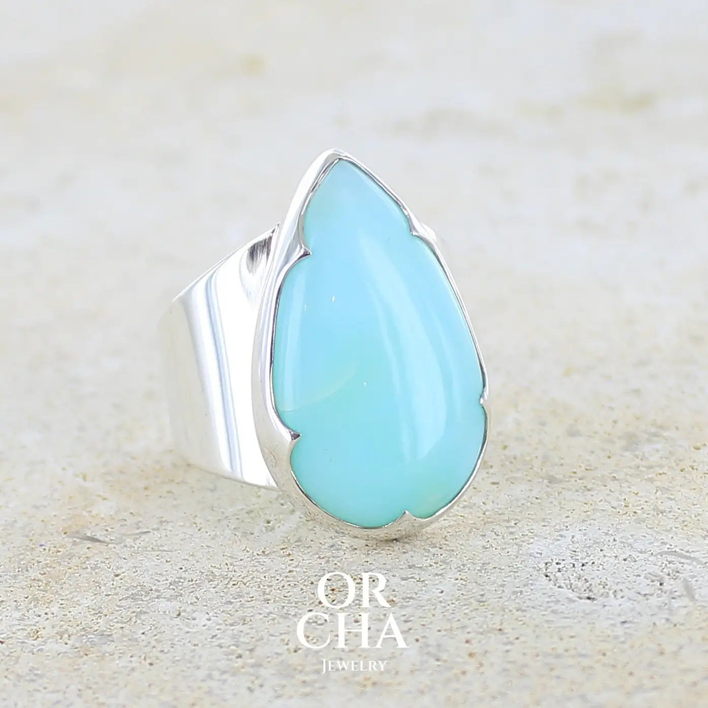 profil droit d'une grande Bague pour femme en argent massif, sertie d'un cabochon d'opale bleue du Pérou de couleur bleu ciel. Pierre taillée en forme de goutte de qualité opaque. Bijou unique réalisé en taille 60 FR.