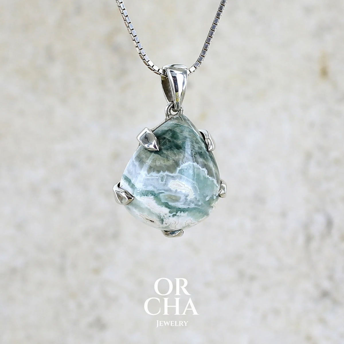 profil droit d'un pendentif pour femme en argent massif sertie d'un cabochon de jaspe océan de couleur nuancée de kaki et crème. Pierre opaque taillée en forme de goutte. Bijou unique par Orchajewelry
