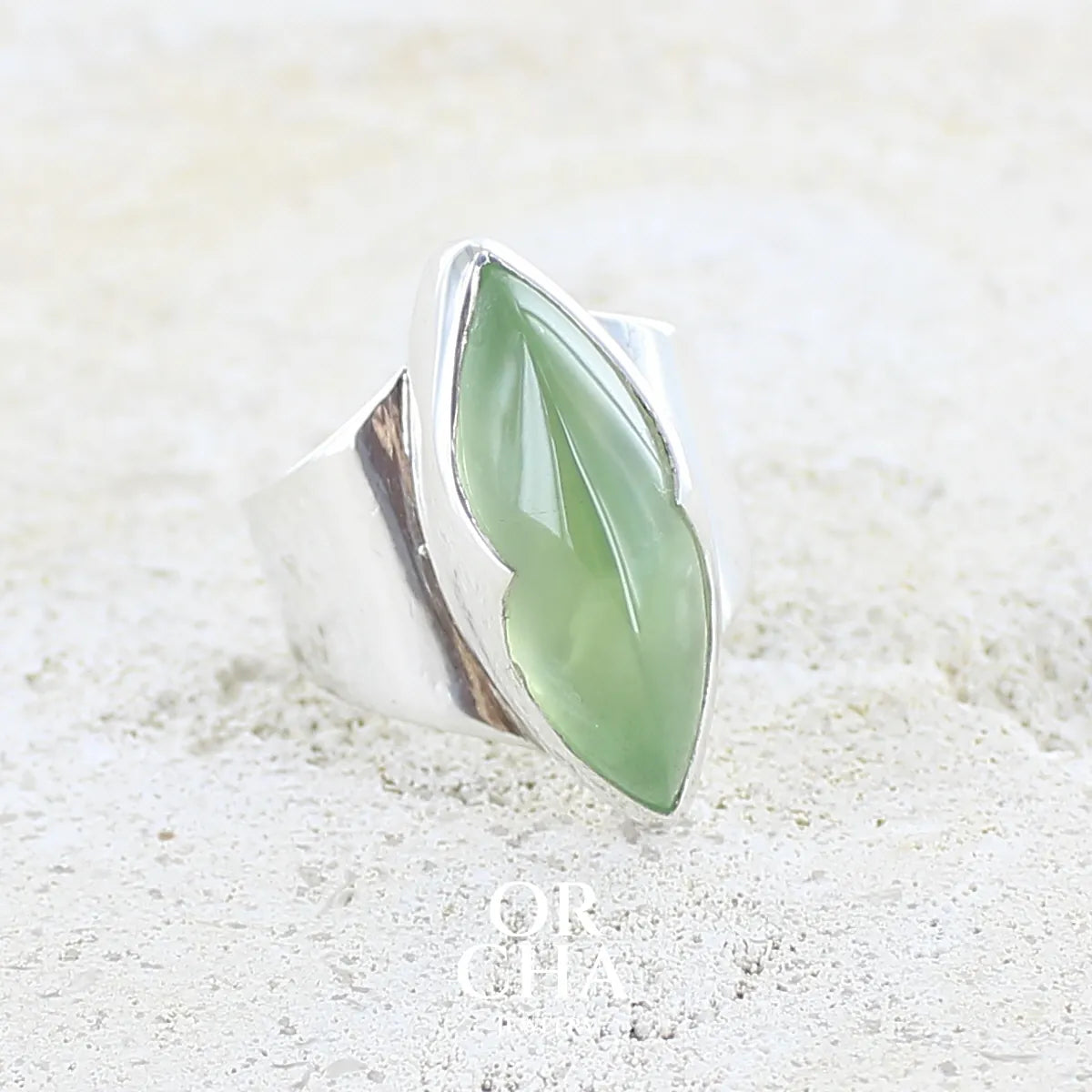 profil gauche d'une bague marquise pour femme en argent massif sertie d'une préhnite de couleur verte jaune clair, Pierre taillée en cabochon en forme de goutte. Pierre gemme de qualité transparente à inclusions. Bijoux unique réalisé en taille 60 par Orchajewelry.