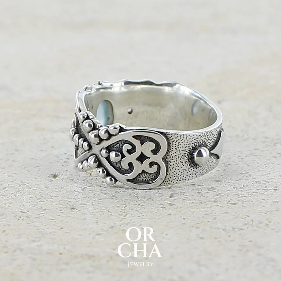 profil gauche d'un Bague anneau pour homme en argent massif d'inspiration celtique, médiévale. Bague sertie d'un cabochon d'aigue-marine de couleur bleu gris. Pierre  translucide propre à l'oeil. Bijou unique réalisé en taille 58. 