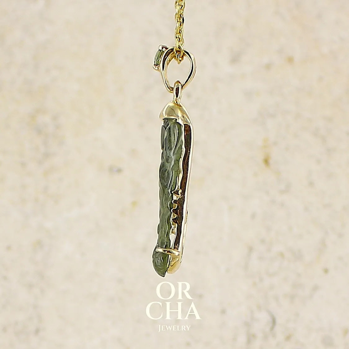 profil d'un pendentif pour homme en or 18k serti d'une moldavite sculptée en tête de crocodile. Pierre naturelle de couleur verte kaki translucide. Bijoux unique par Orcha jewelry