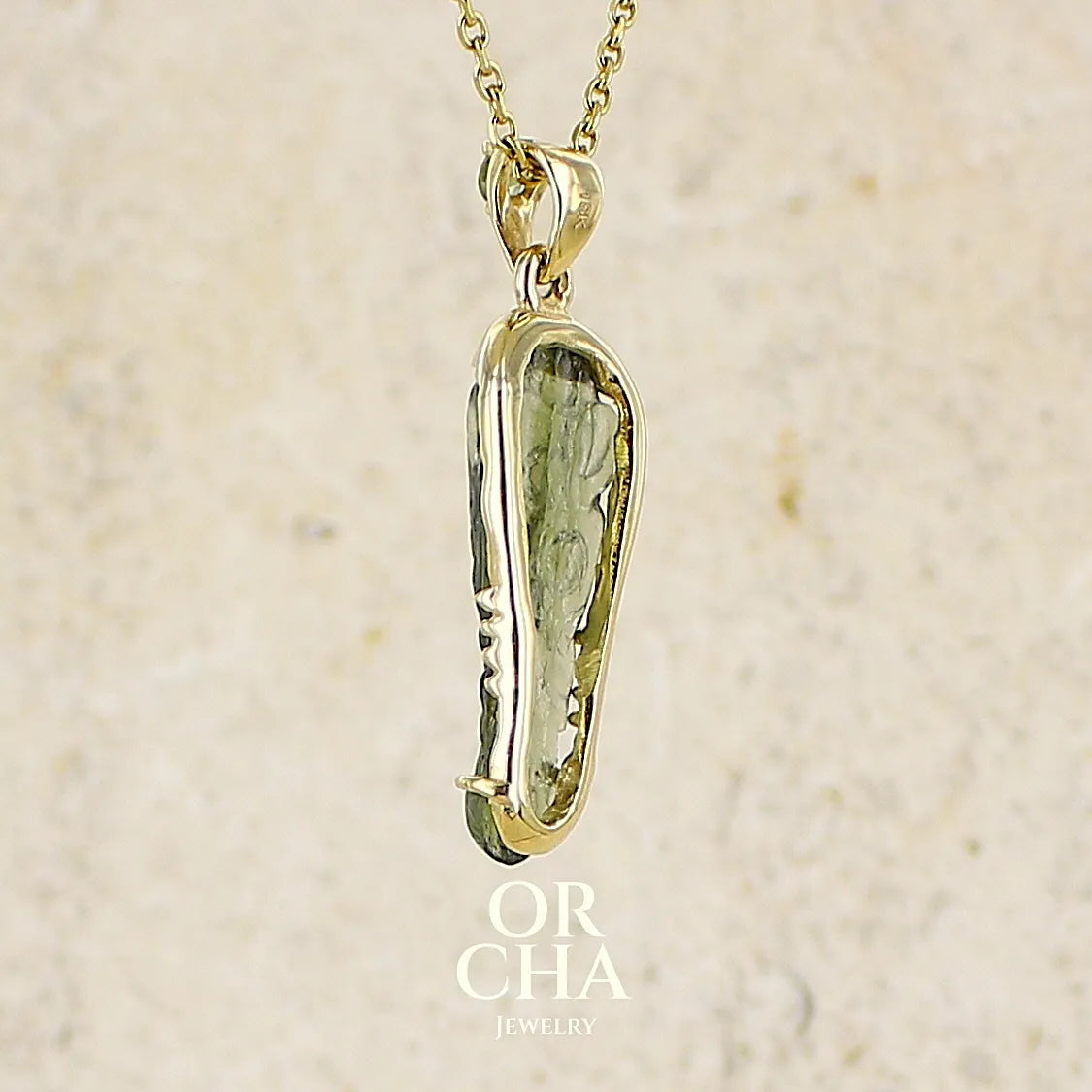 profil d'un pendentif pour homme en or 18k serti d'une moldavite sculptée en tête de crocodile. Pierre naturelle de couleur verte kaki translucide. Bijoux unique par Orcha jewelry